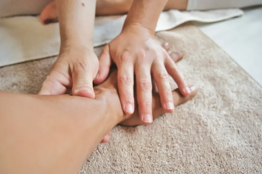 Fisioterapia muscular a domicilio Manos del fisioterapeuta tratando a un paciente en Valencia